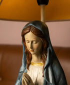 Statue of a religious figure with a blurred lamp in the background