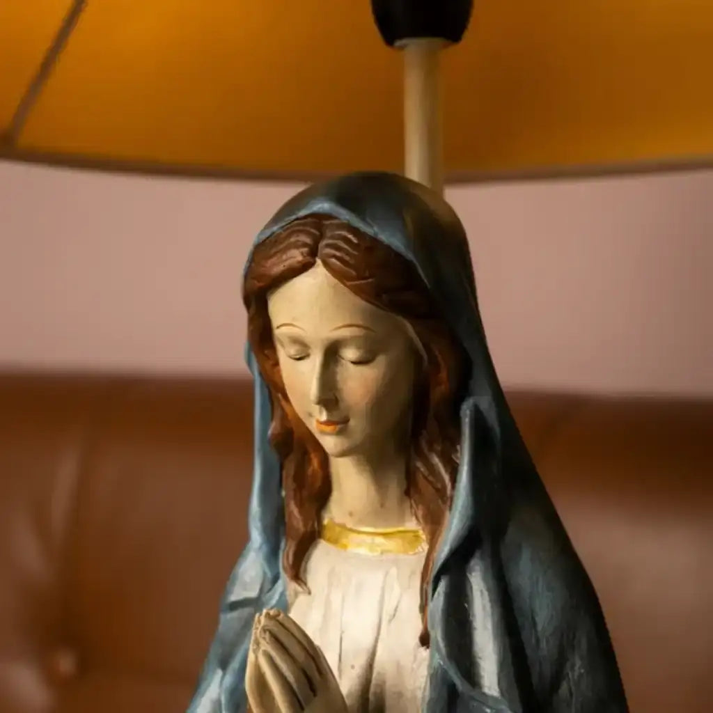 Statue of a religious figure with a blurred lamp in the background