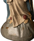 Wooden statue of a religious figure with a blue garment and gray skirt on a white background