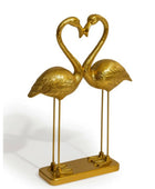 Gold flamingo sculpture forming a heart shape on a white background