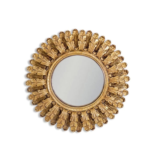 Decorative gold mirror with sunburst design on a white background