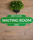 Green sign with 'First Class Waiting Room Only' text on a white background