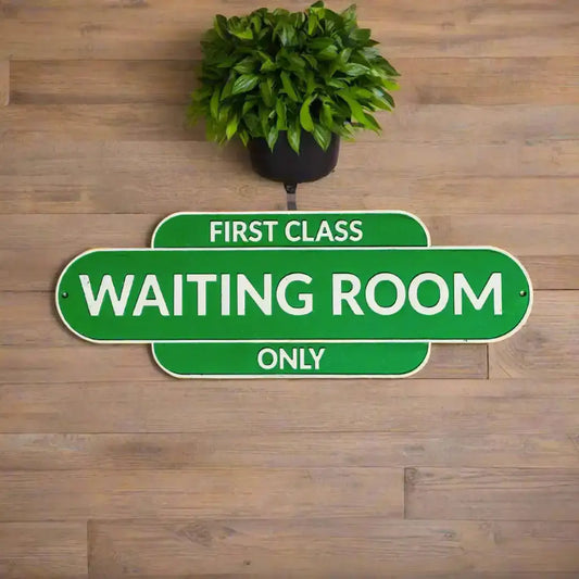 Green sign with 'First Class Waiting Room Only' text on a white background
