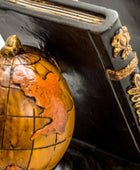 Decorative globe with intricate detailing on a dark background