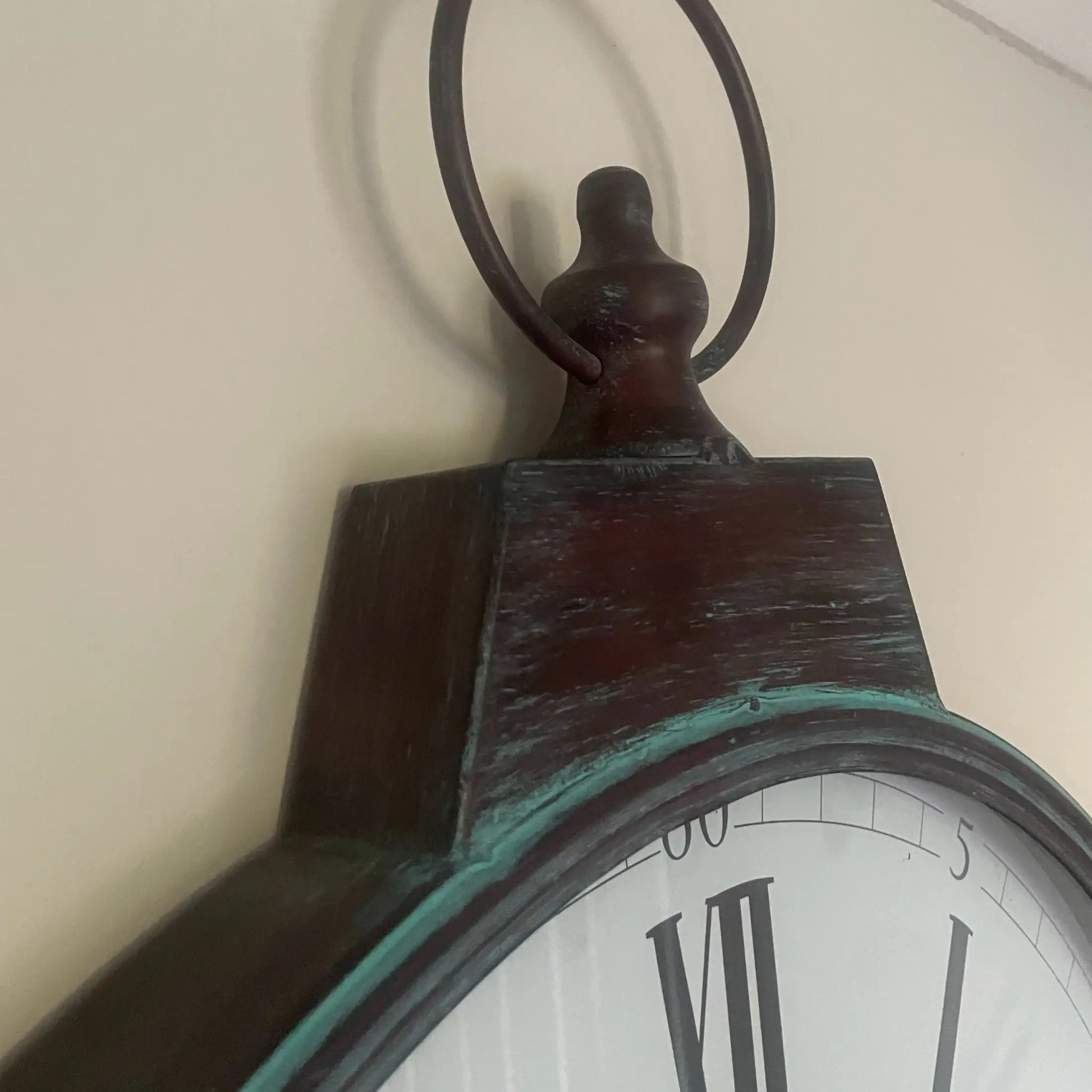 Close-up of an antique clock with a wooden frame and white face.