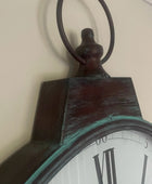 Close-up of an antique clock with a wooden frame and white face.
