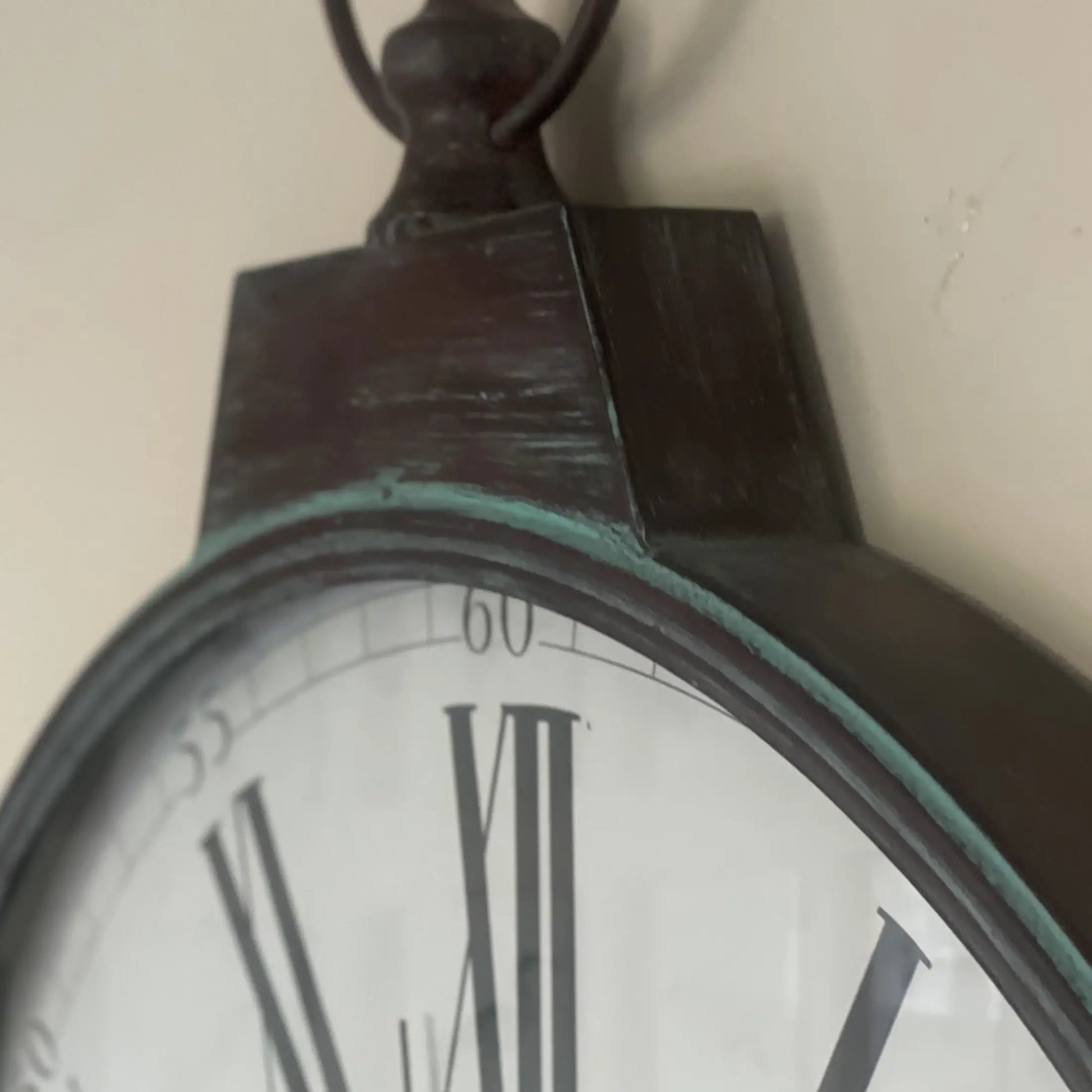 Close-up of a pocket watch with Roman numerals on a plain background