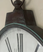 Close-up of a pocket watch with Roman numerals on a plain background