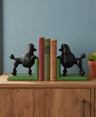 Black poodle-shaped bookends on a wooden cabinet with books and a plant.