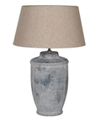 Table lamp with textured gray base and beige lampshade on a white background