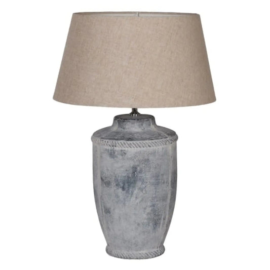 Table lamp with textured gray base and beige lampshade on a white background