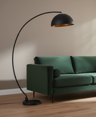 Green sofa with a black floor lamp against a beige wall