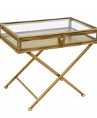A gold-finished metal side table with a glass top, a single drawer with a glass front and round gold knob, and an X-shaped folding base, shown on a white background.