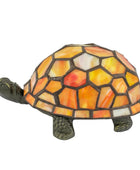 A decorative tortoise figurine with a mosaic stained-glass shell in shades of orange, yellow, and white, set against a plain white background.