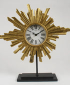 Decorative clock with sunburst design on a stand against a gray background