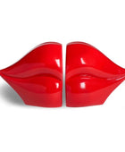 A pair of glossy red novelty chairs shaped like lips, set against a plain white background.