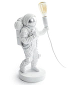 White astronaut lamp with a light bulb on a white background