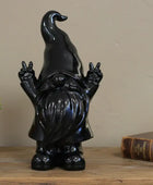 Black ceramic gnome figurine making peace signs against a stone wall background