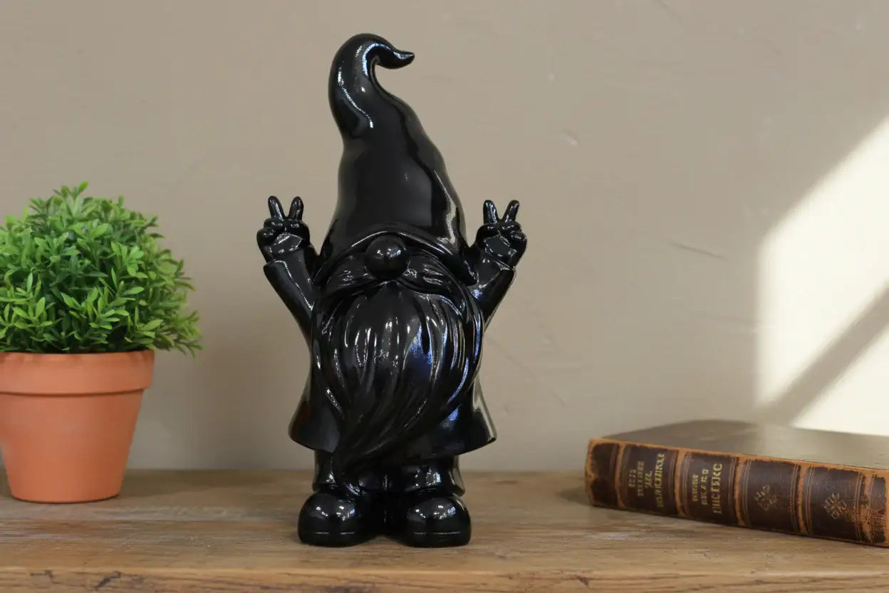 Black ceramic gnome figurine making peace signs against a stone wall background