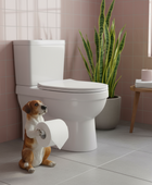 Dog figurine holding a roll of toilet paper next to a toilet in a bathroom.