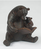 Bronze statue of a bear holding a cub on a white background
