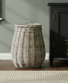 Wicker laundry basket on a wooden floor with a neutral wall and cabinet in the background