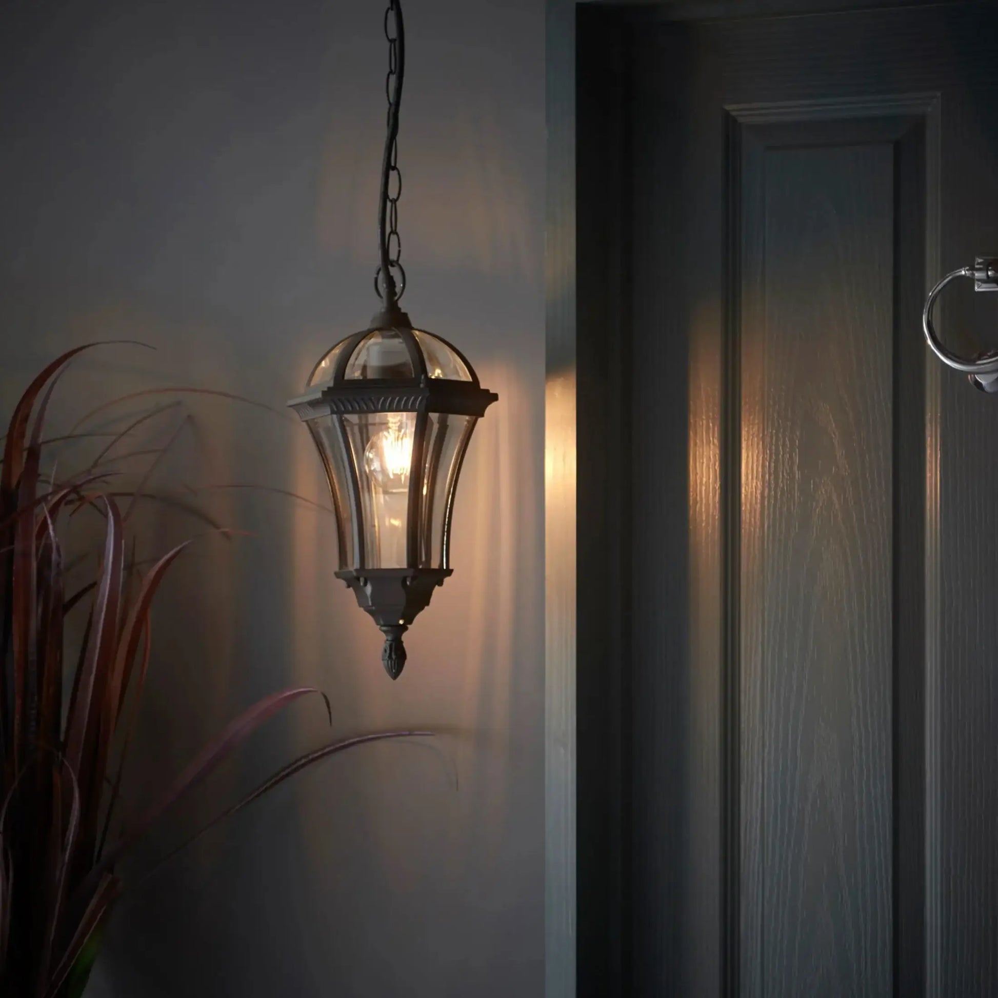 Decorative hanging light fixture on a wall next to a door