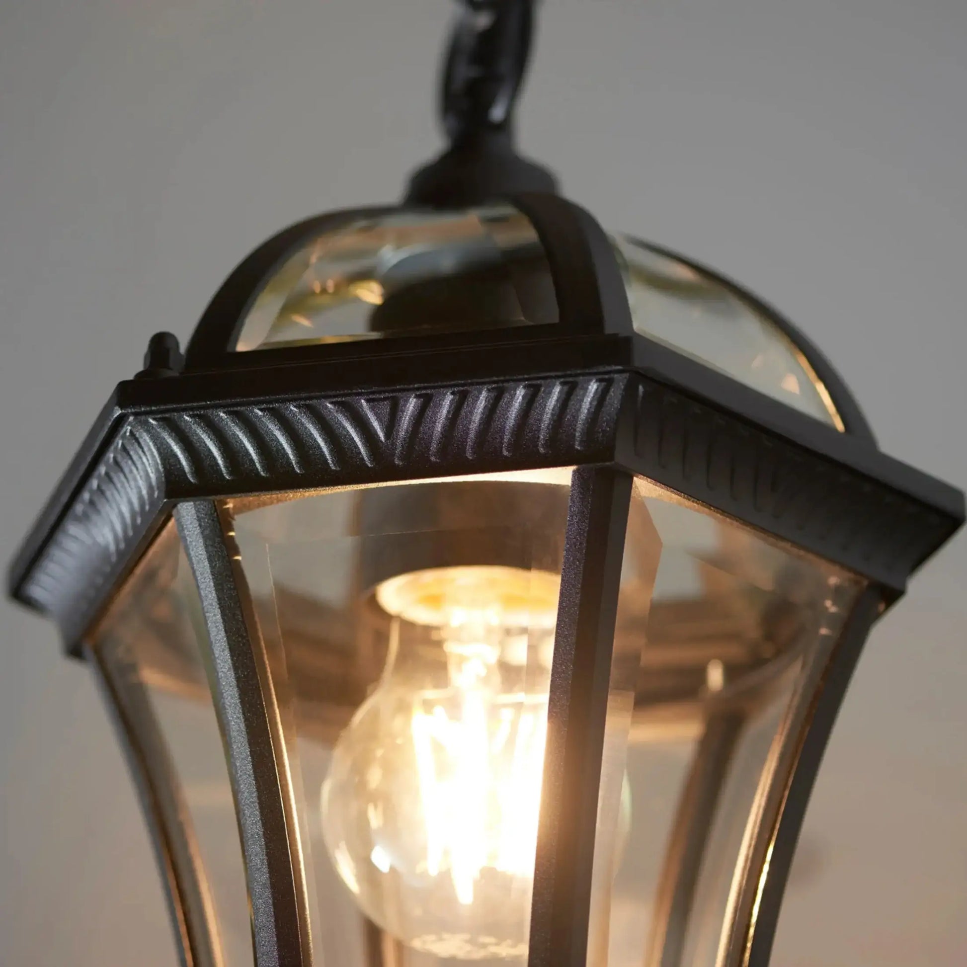 Close-up of a vintage-style outdoor light fixture with a clear glass cover.