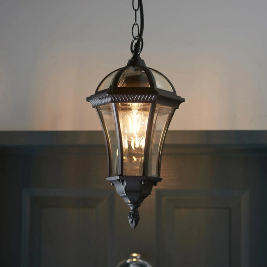 Vintage-style hanging lantern with a warm glow against a dark background