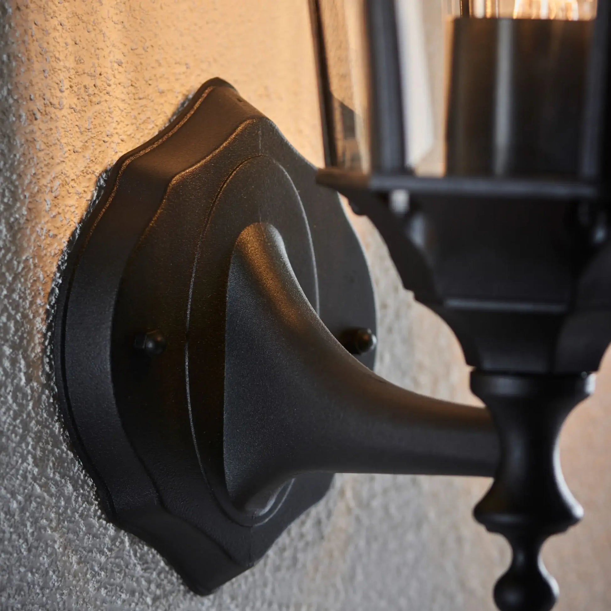 Black metal door handle on a textured wall