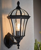 Black outdoor wall light fixture on a textured wall with a blurred background