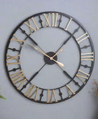Large round wall clock with black and gold details on a white background