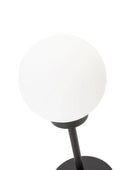 Table lamp with a white globe shade and black base on a white background