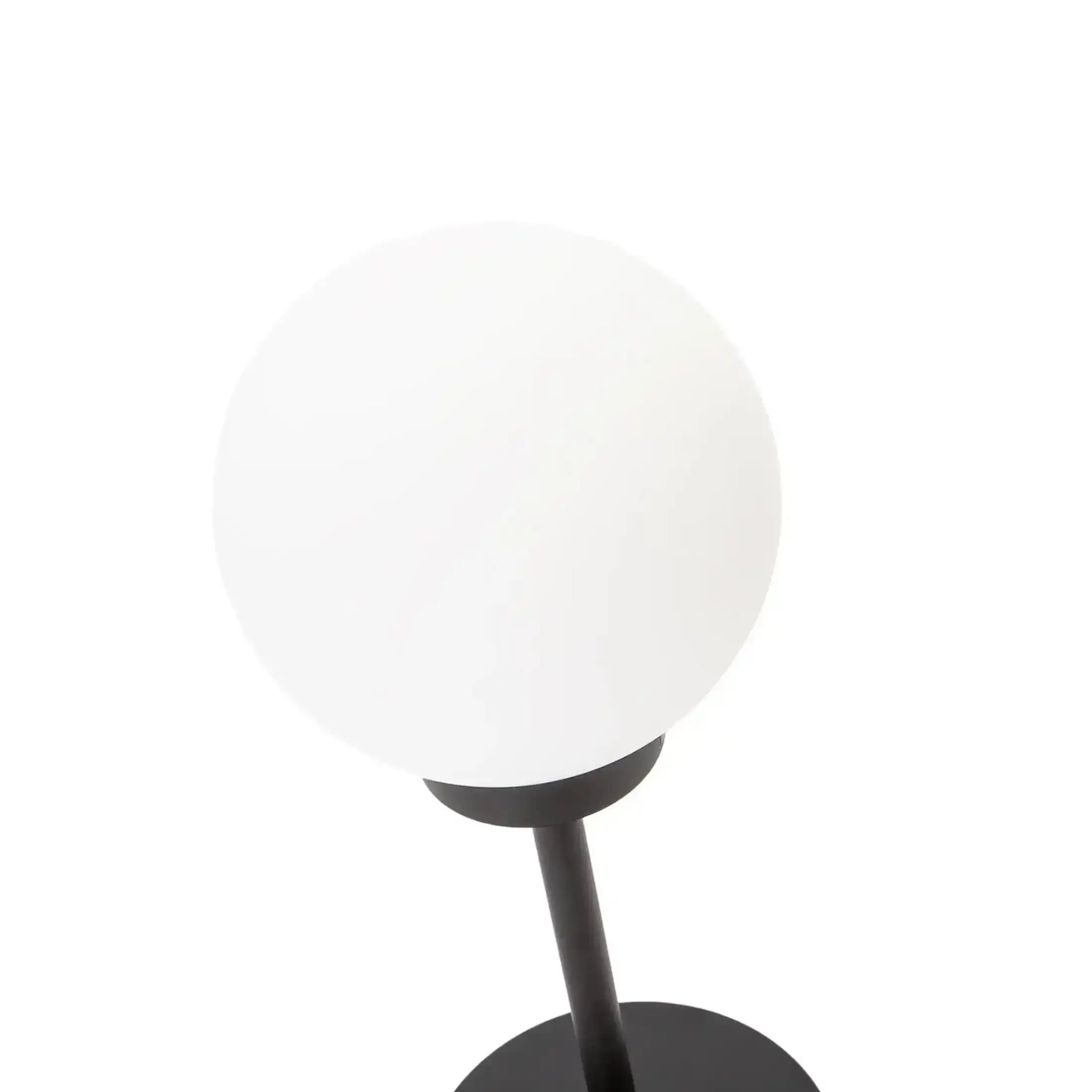 Table lamp with a white globe shade and black base on a white background