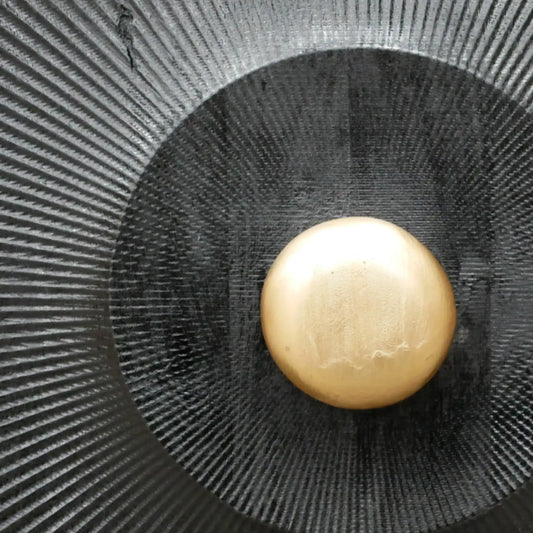 Gold button on a black textured background