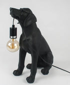 Black dog-shaped lamp with a light bulb on a white background