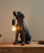 Dog-shaped table lamp with a light bulb on a wooden surface.