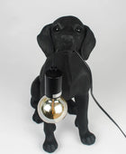 Black dog-shaped lamp holding a light bulb on a white background