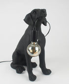 Black dog-shaped lamp with a light bulb inside on a white background