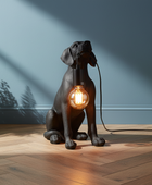 Dog-shaped lamp with a light bulb inside on a wooden floor with plants.