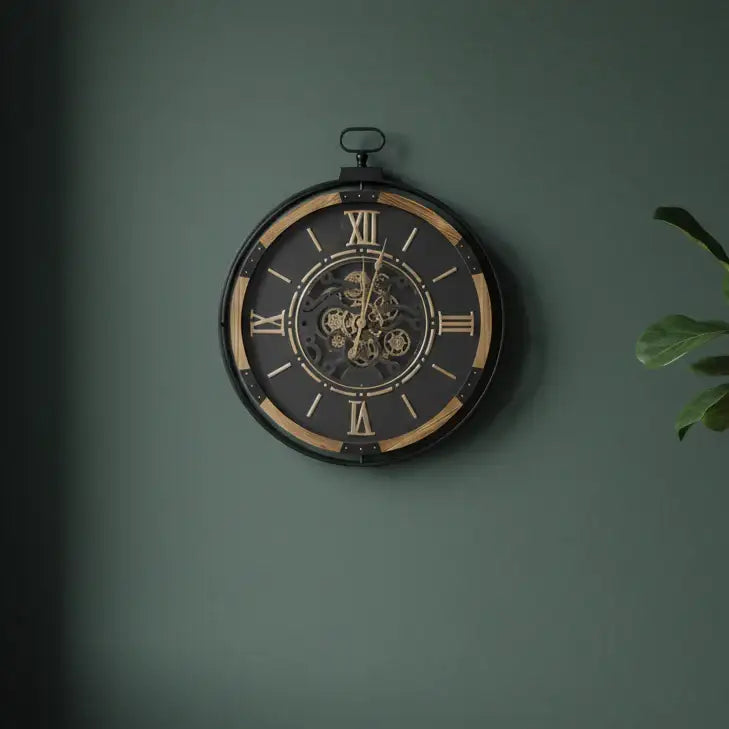 Decorative wall clock with Roman numerals on a green wall