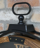Close-up of a black and wooden clock against a brick wall.
