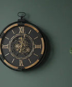 Decorative wall clock with Roman numerals on a green wall