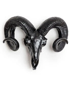 Decorative black ram's head with large curved horns on a white background