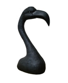 Black flamingo sculpture on a wooden surface with a white background