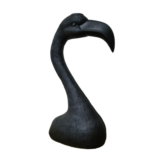 Black flamingo sculpture on a wooden surface with a white background