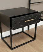 Black hexagonal patterned drawer on a gray textured surface