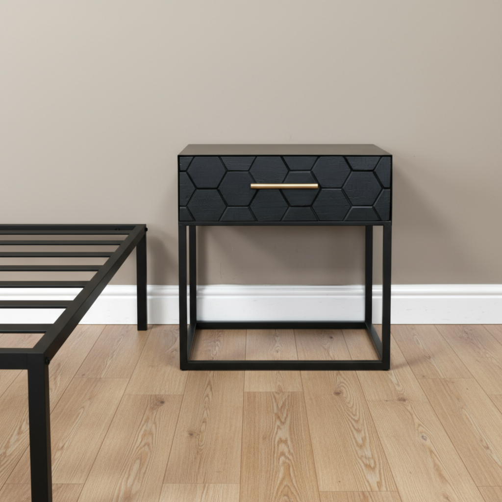 Black hexagonal patterned nightstand with a gold handle on a wooden floor.