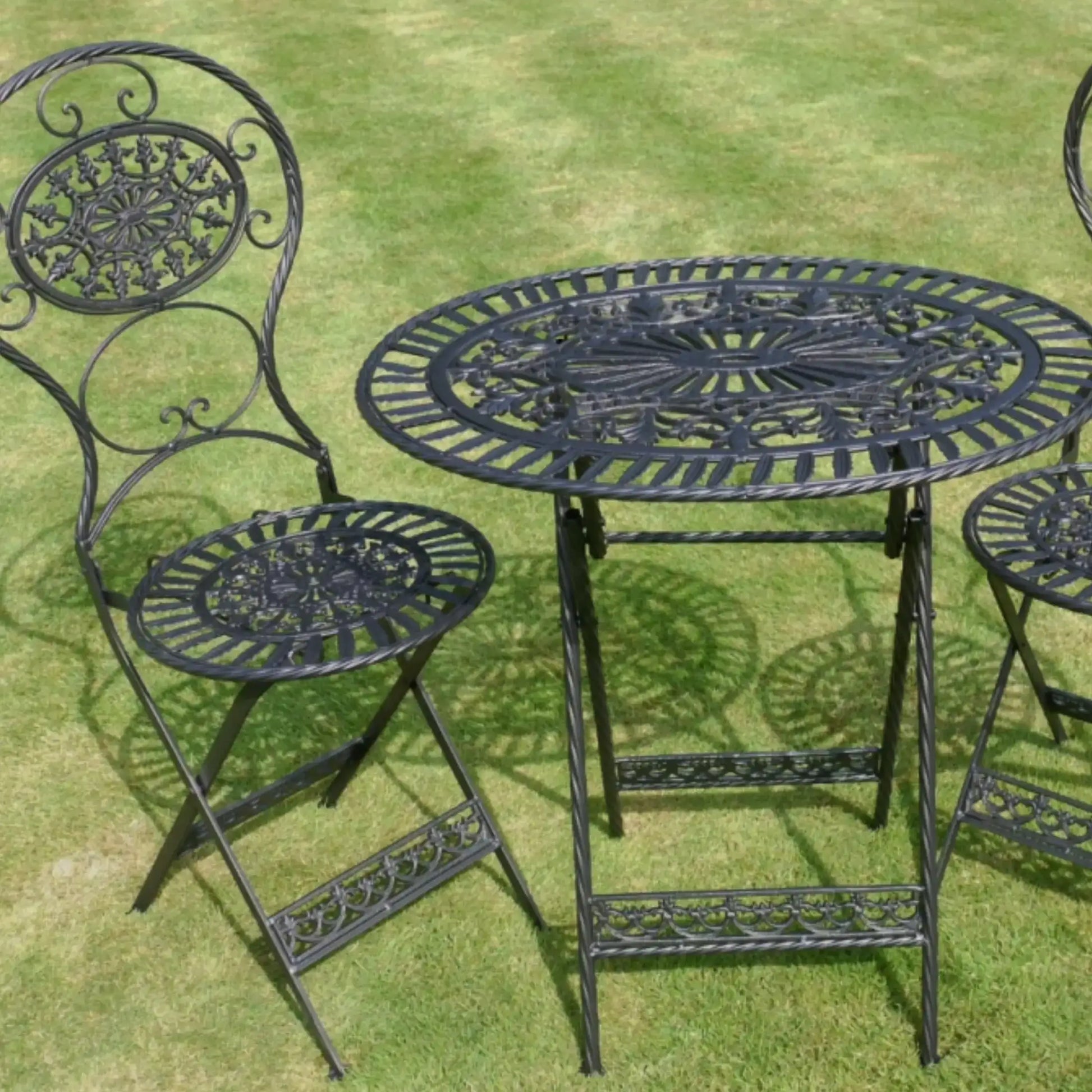Black metal garden table and chairs on grass