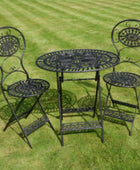 Black metal garden table and chairs set on a grassy background